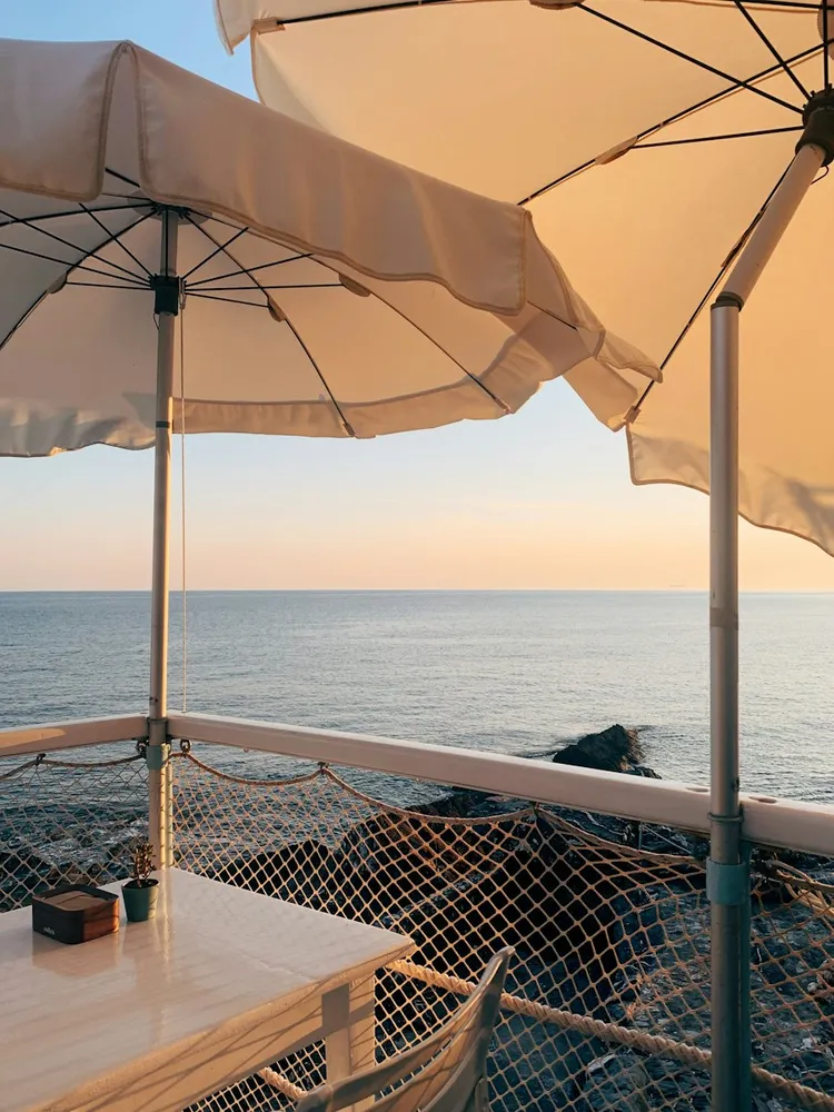 Mesa y sillas en una terraza junto al mar