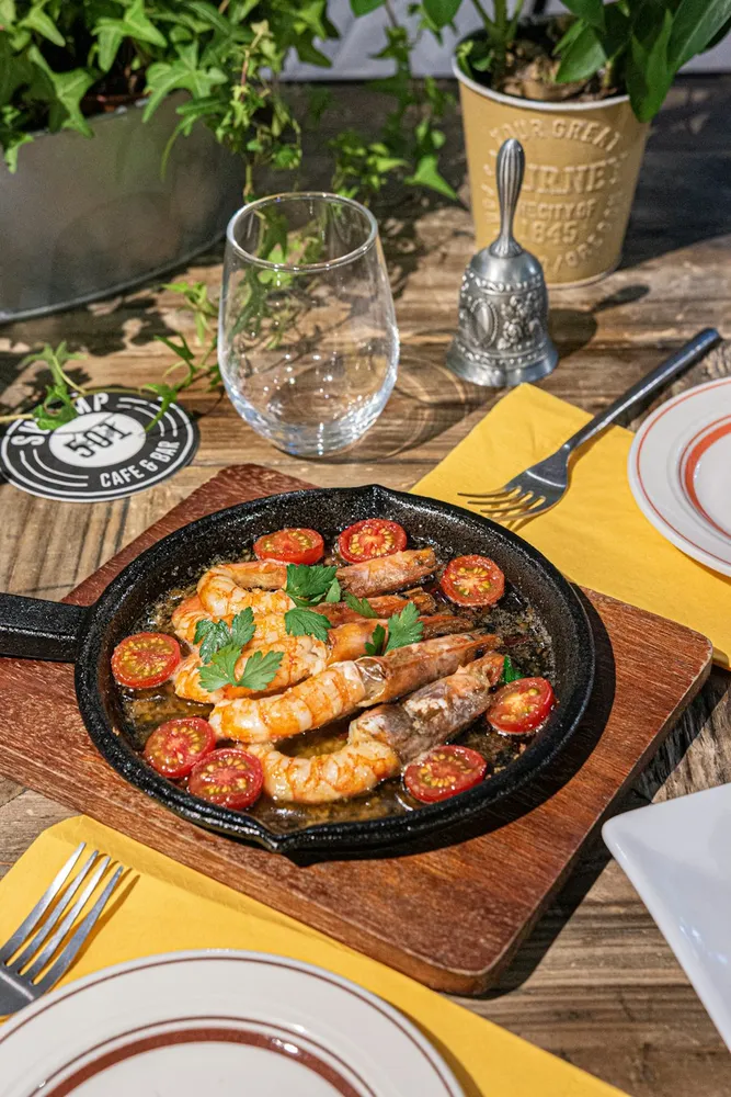 Gambas y tomates en una sartén