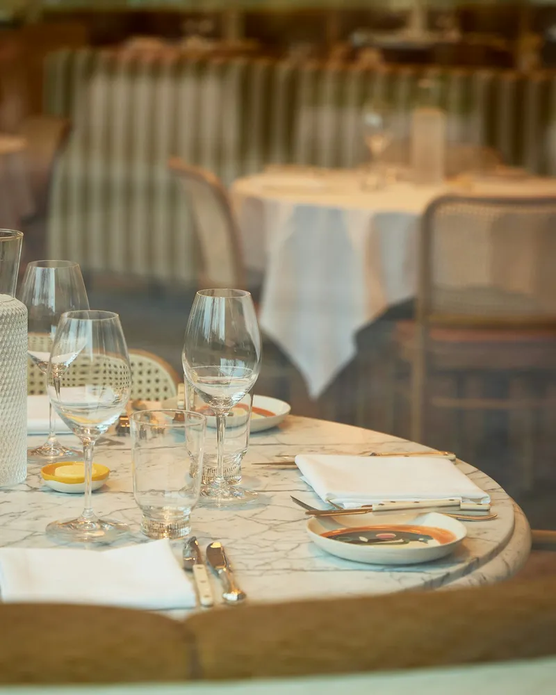 Mesas puestas con copas y platos para una cena privada